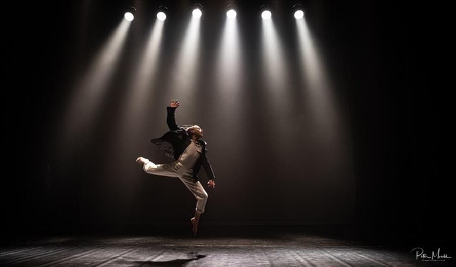 dancer leaping on a spotlit stage