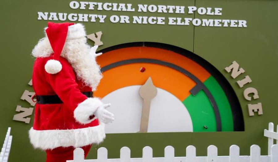 Father Christmas stood by a large gauge marked at each end as naughty and nice.