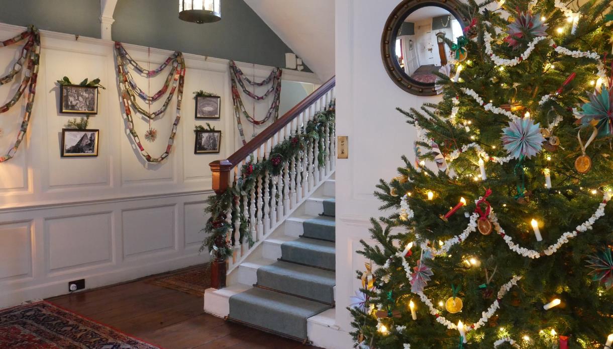 Christmas at Lamb House featuring a decorated tree, festive garlands and a historic staircase adorned for the season.