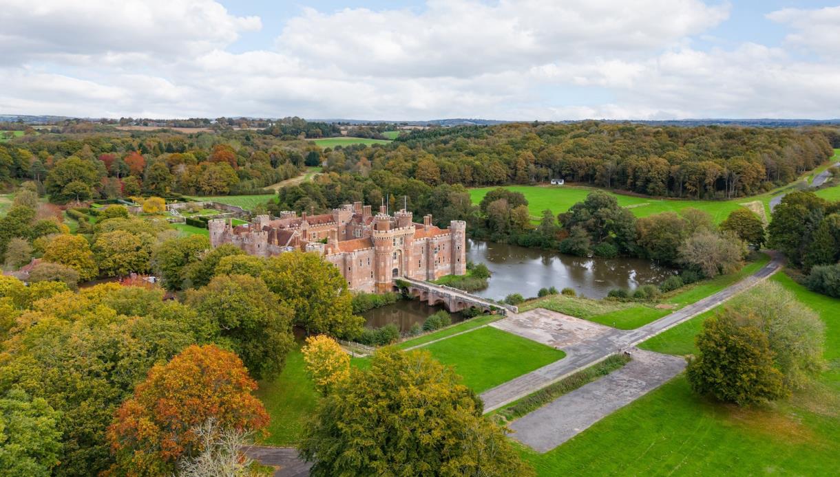 Aerial view of Herstmonceux Castle estate surrounded by lakes, woodland and countryside in East Sussex.