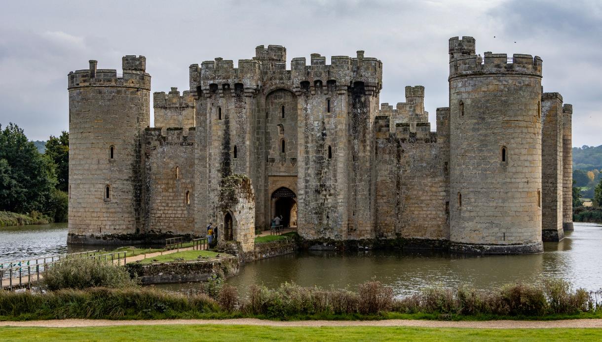 Bodiam Castle surrounded by its moat, showcasing towers, battlements and the historic gatehouse.