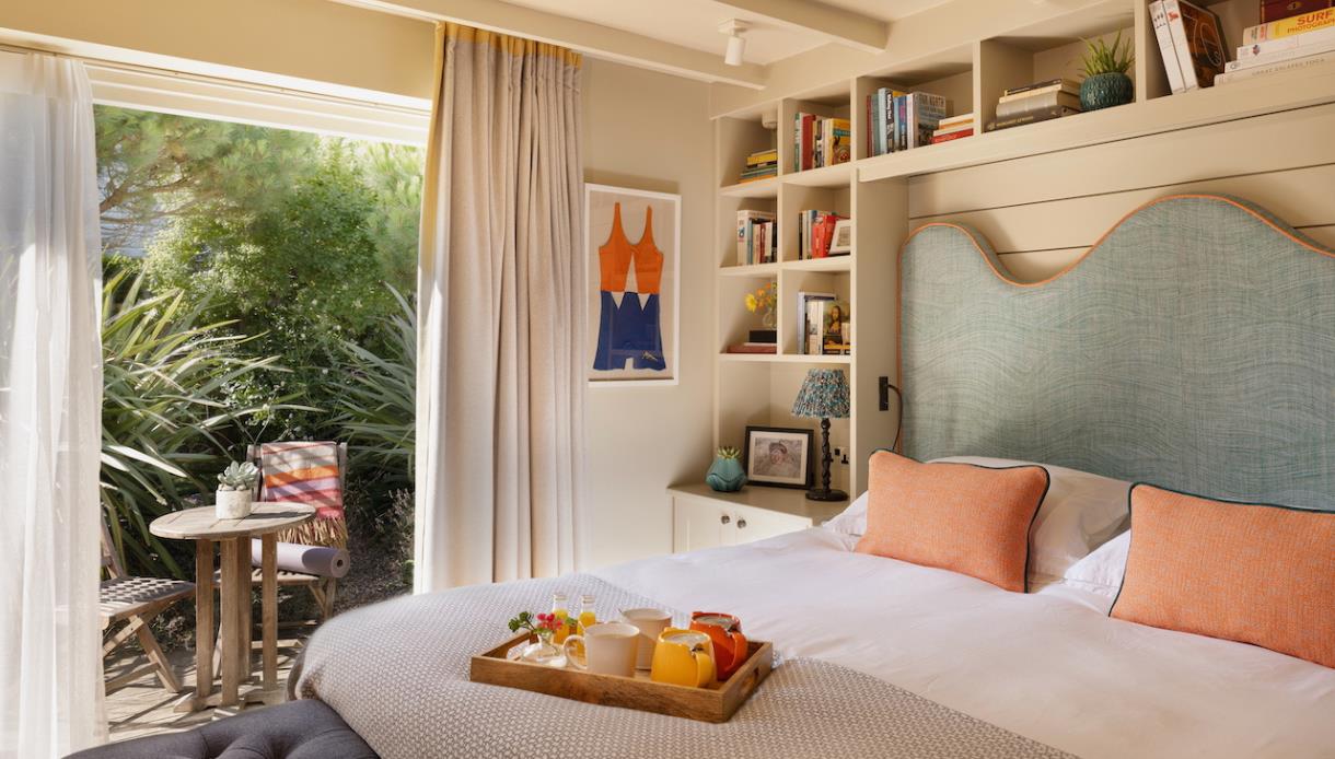 Elegant guest room at The Gallivant with garden terrace, reading nook and breakfast tray.