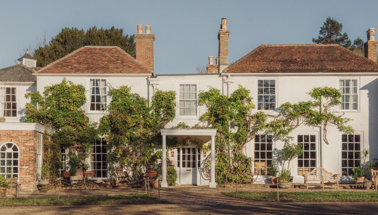 Front view of Crafted at Powdermills with white facade, tiled roof and greenery climbing the walls.