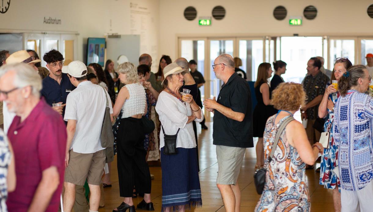 Guests socialise and enjoy refreshments at the Autumn Exhibitions Opening Party in a busy gallery foyer.