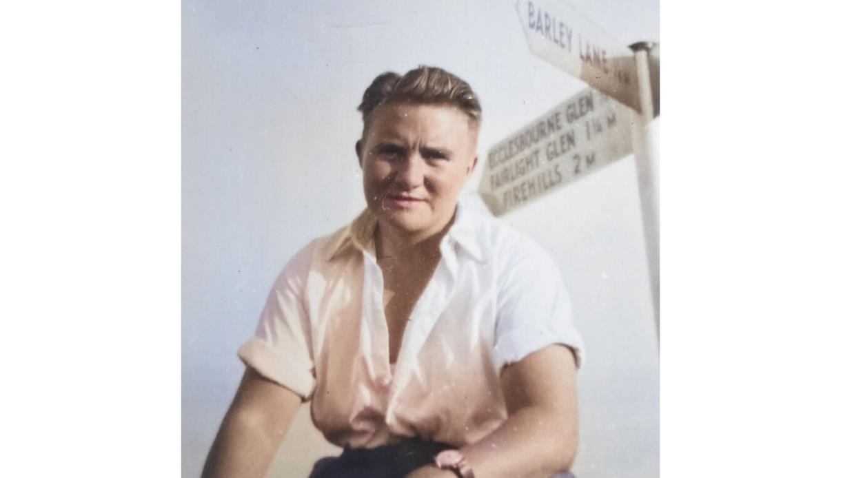 Historic photo from Lemons, Laws & Secret Doors at Hastings Museum, showing a person in a white shirt by a signpost.