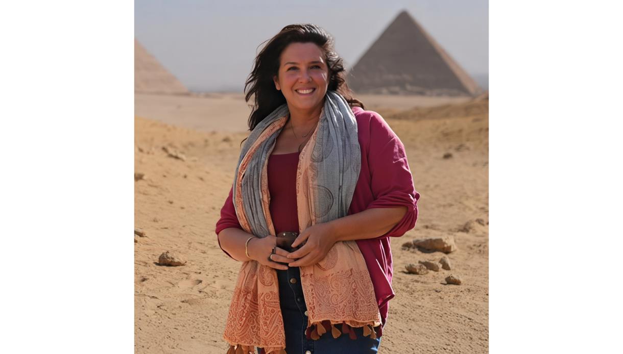 Portrait of Bettany Hughes in desert landscape with pyramids behind, promoting DLWP event.