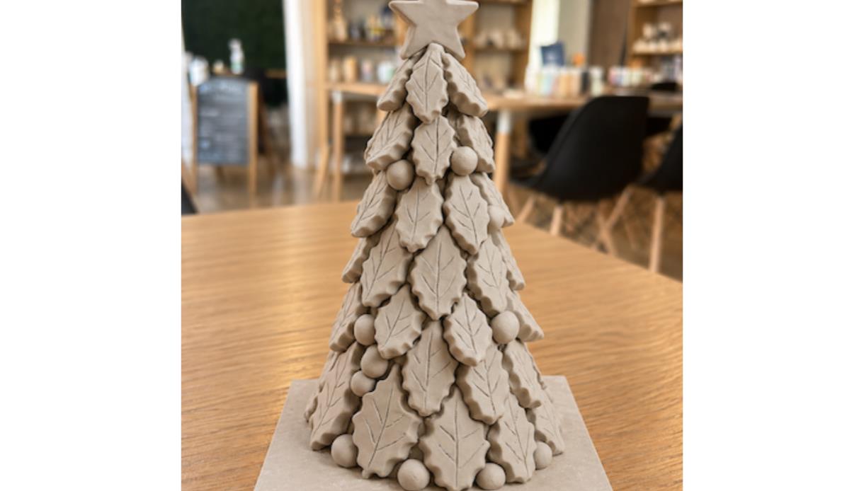 Handcrafted ceramic Christmas tree with layered leaf details and star topper, created in a festive pottery workshop.
