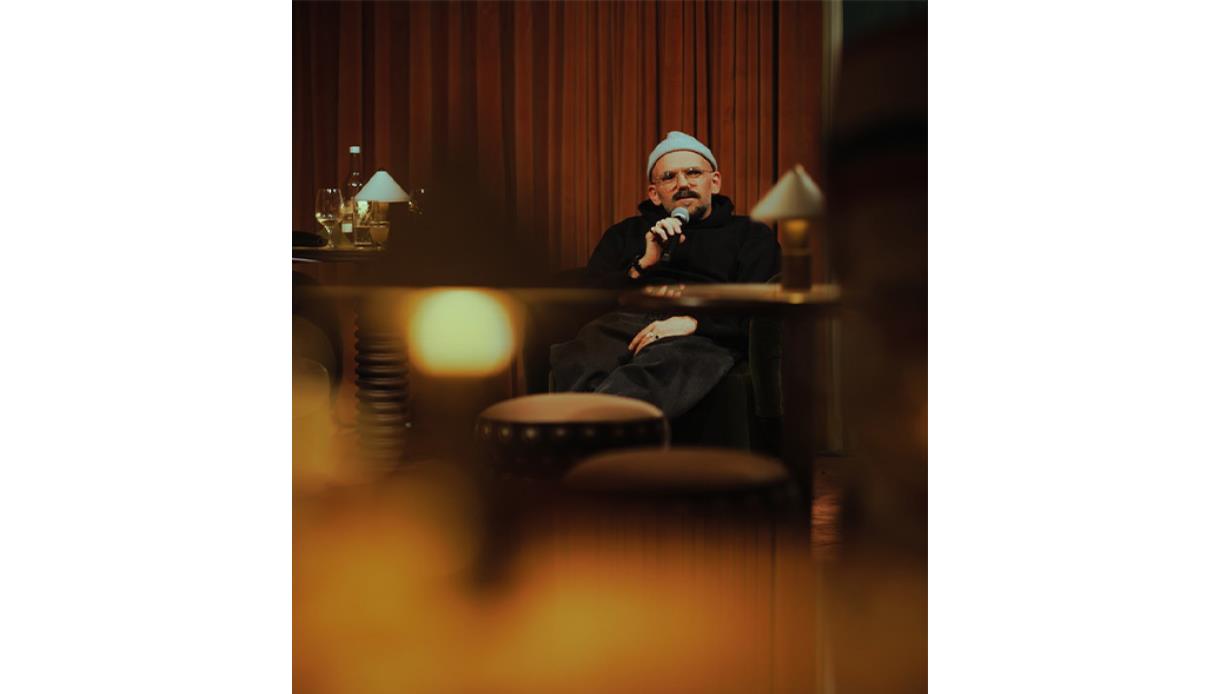 Promotional image for An Evening with Ryan Gander and Holly Walsh, showing a speaker seated on stage with a microphone.
