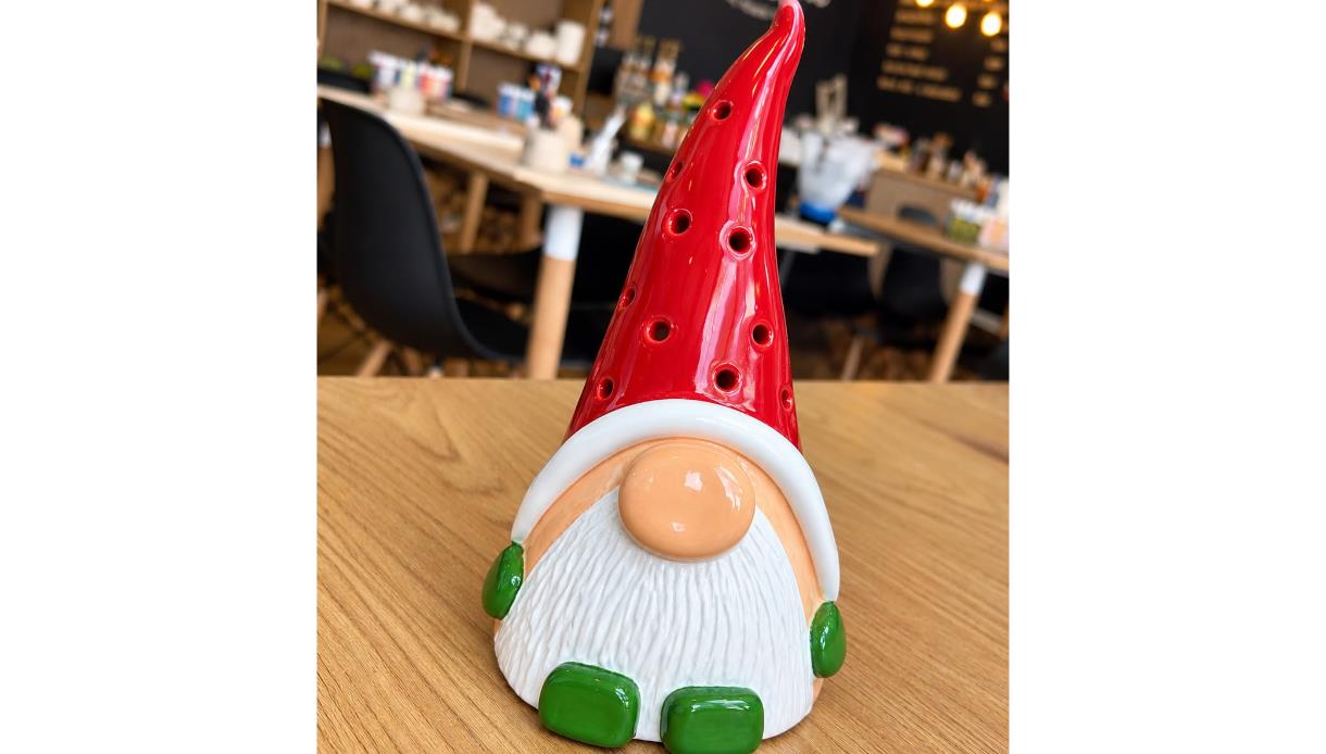 Handcrafted ceramic Christmas gonk with a red hat and white beard, created in a festive pottery workshop.