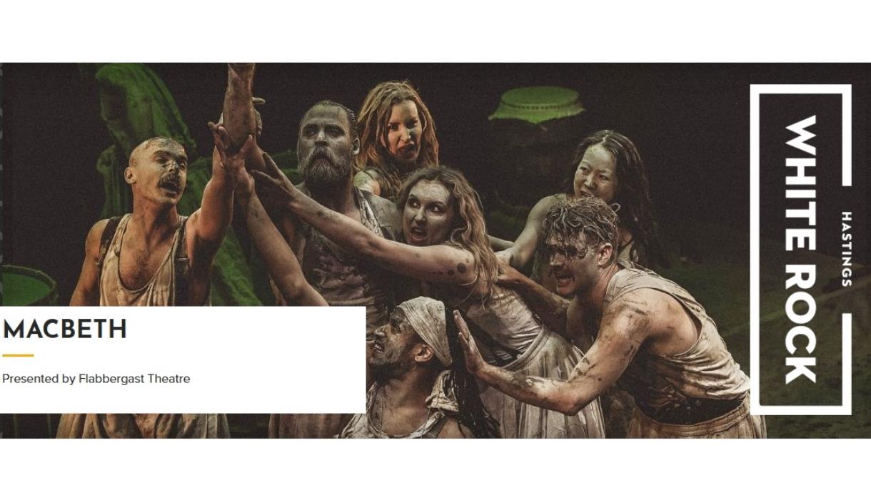 Actors in mud‑covered costumes performing a dramatic group scene from Macbeth, promoted by White Rock Hastings.