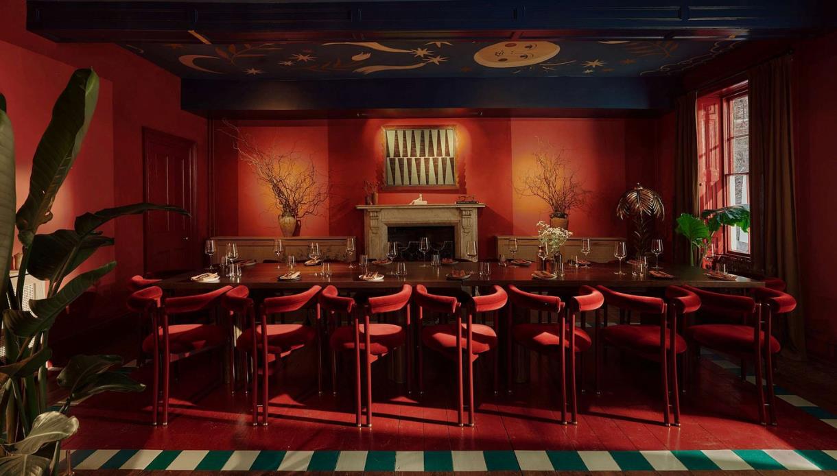Crafted at Powdermills dining room with rich red interiors, long communal table and a hand-painted celestial ceiling.