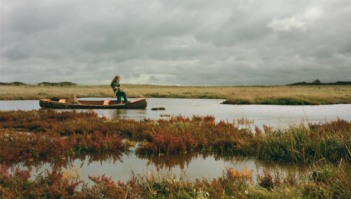Promotional image for Edge: Where the Land Meets the Sea at Hastings Contemporary, showing a boat on marshland waters.
