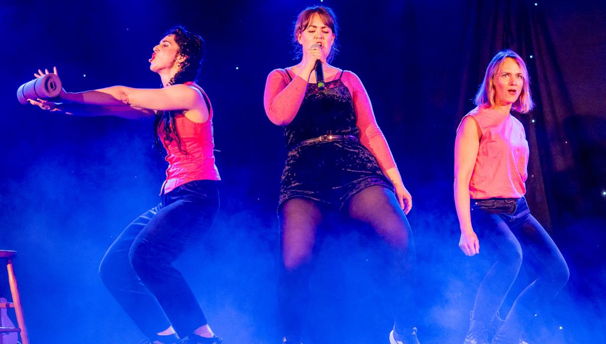 Stage performance by Fannytasticals at the White Rock Theatre, featuring three performers under colourful theatre lighting.