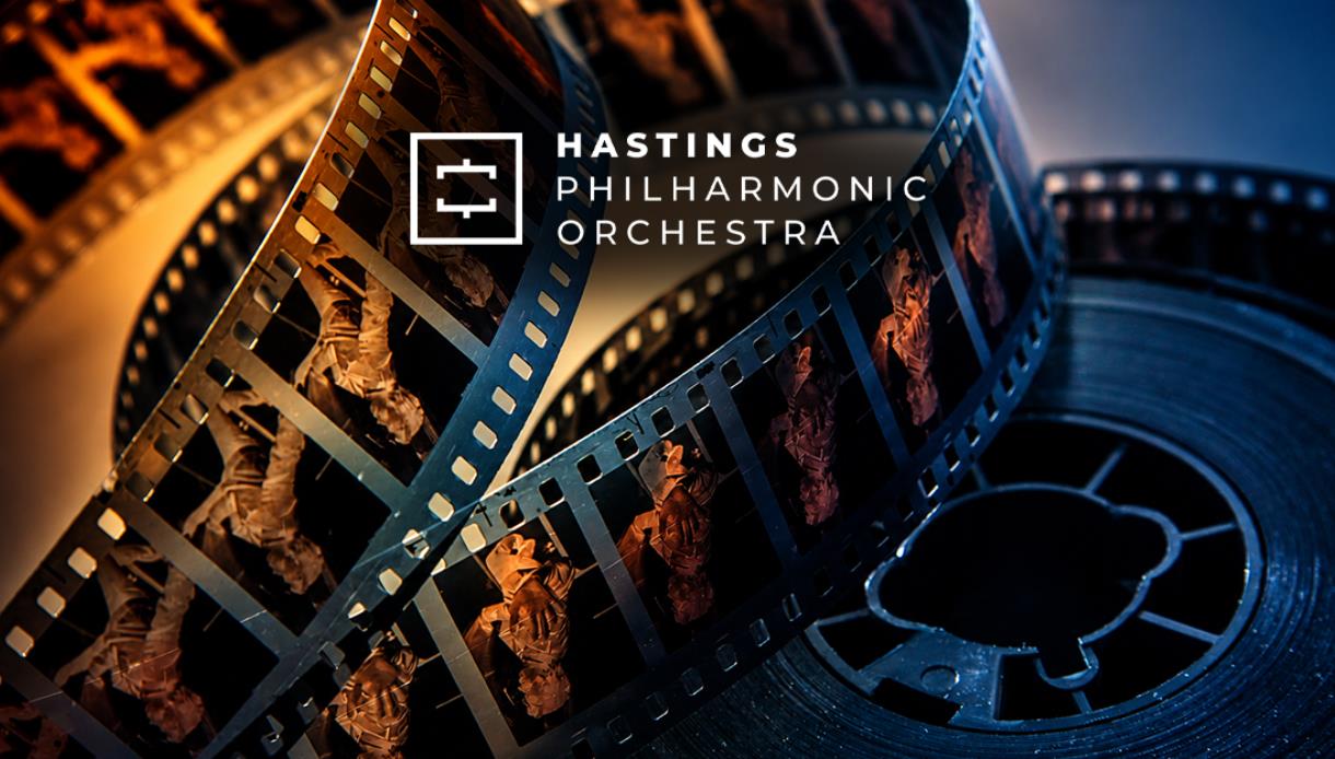 Film reels illuminated in blue and gold tones, promoting Hastings Philharmonic Orchestra's Beyond the Screen concert.