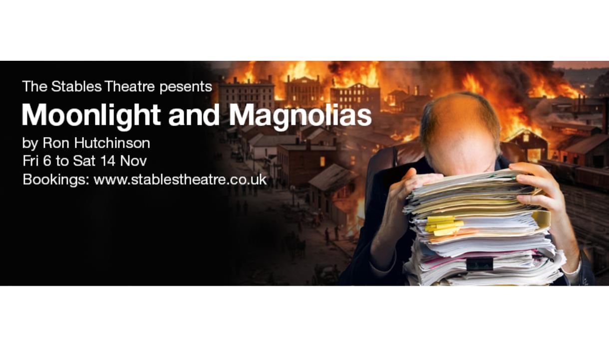 Poster for “Moonlight and Magnolias” featuring a person buried in paperwork against a backdrop of a city fire.