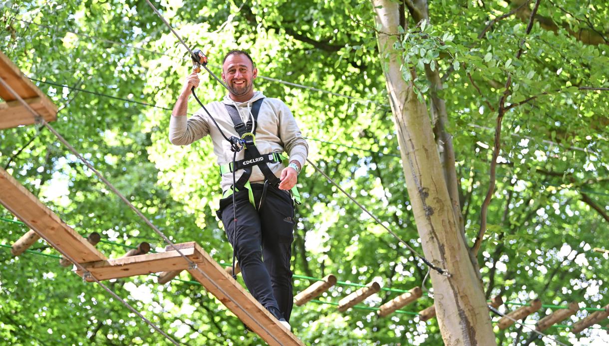Person crossing a high ropes course at Go Ape Bedgebury during the Dadventure experience in a woodland setting.