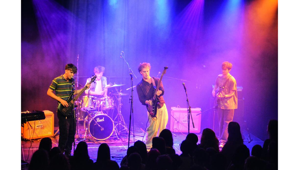 Live band performing on stage at Sounds from the City: Next Wave event at De La Warr Pavilion, with colourful stage lighting.