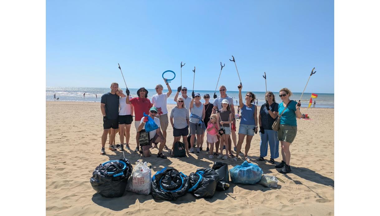 Volunteers gather on the beach with litter pickers and collected rubbish during a community beach clean at The Gallivant.