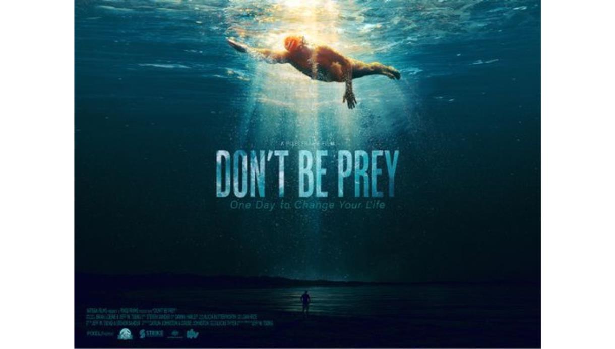 Poster showing a swimmer near the water’s surface with light shining down and the title ‘Don’t Be Prey.