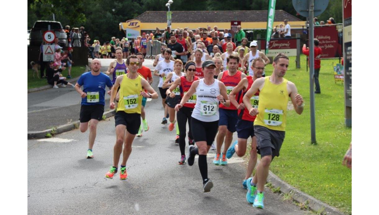 Runners take part in the Rye Half Marathon and 10K, racing along a road lined with spectators