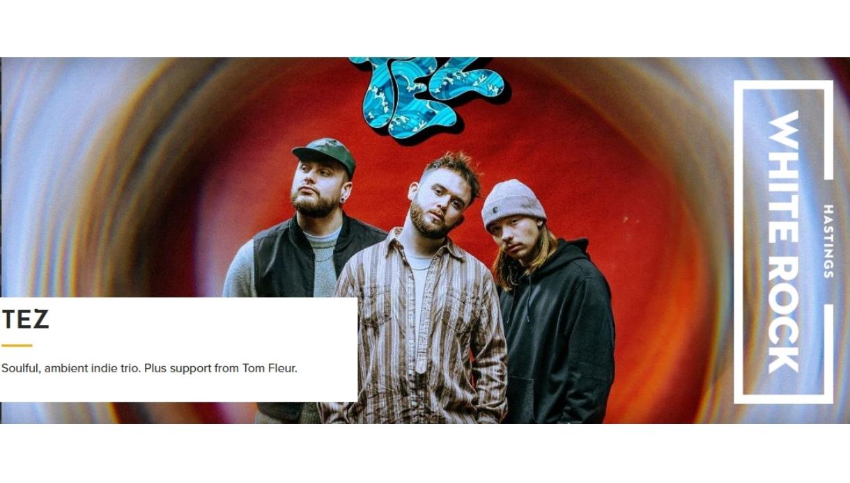 Promotional image of indie trio TEZ standing before a colourful abstract backdrop, with event details and White Rock Hastings branding.