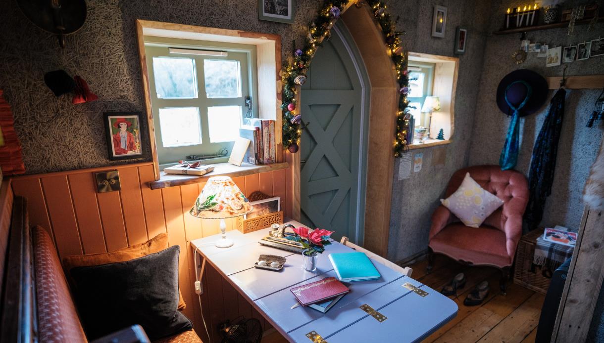 Cosy Christmas reading retreat at Starcroft Farm Cabins, featuring a warm festive cabin with books, fairy lights and comfy seating.
