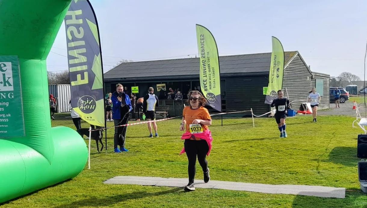 Promotional image for Brett Lydd Half Marathon & 20 Mile, showing runners crossing the finish line outdoors.