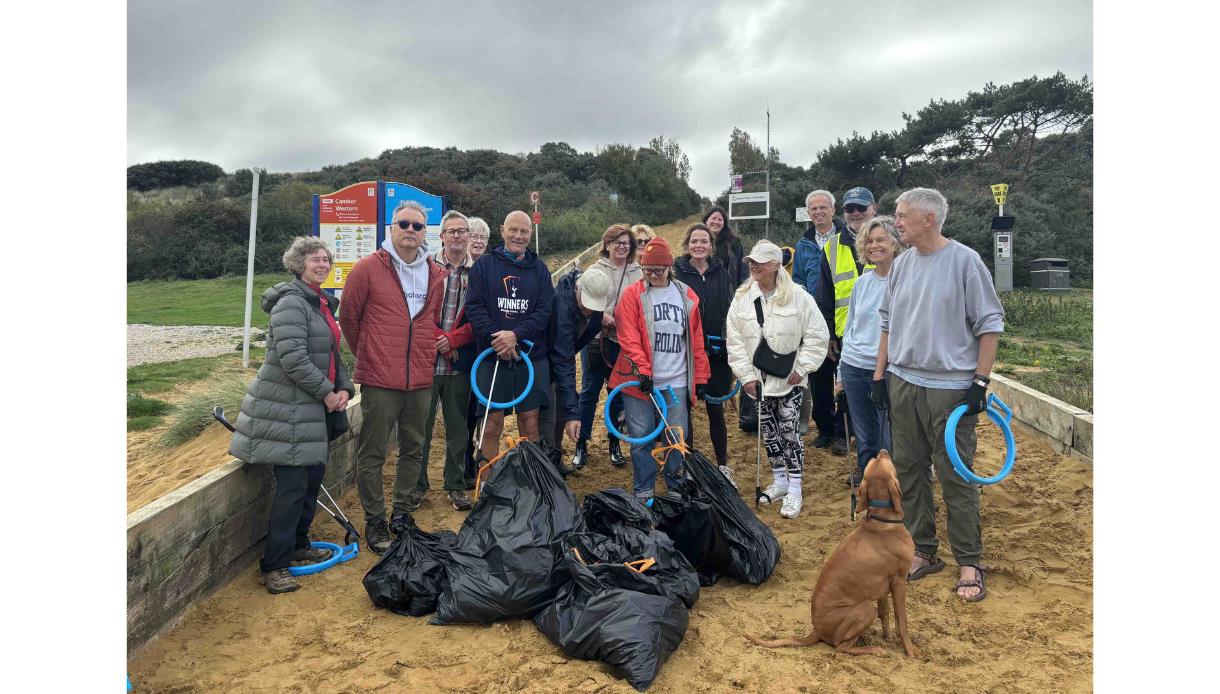 Group at The Gallivant’s Community Beach Clean holding litter pickers and bags filled with collected rubbish.