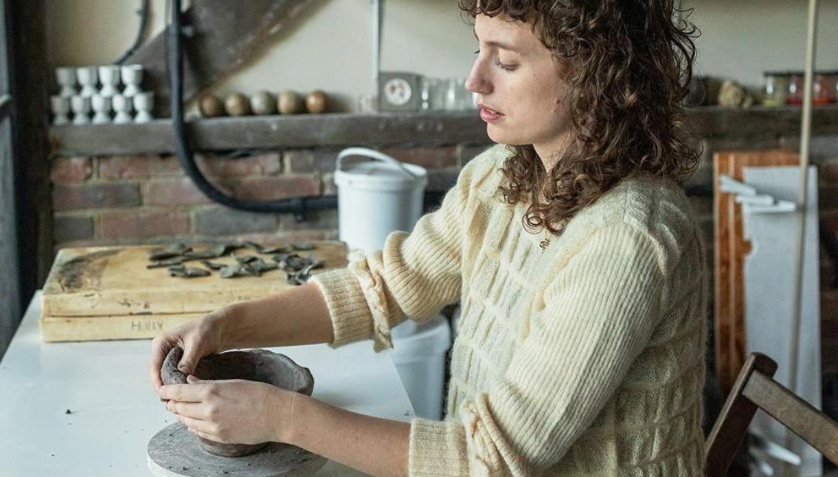 Person shaping a clay vessel during a pottery workshop at Crafted at Powdermills, inspired by haunted houses.