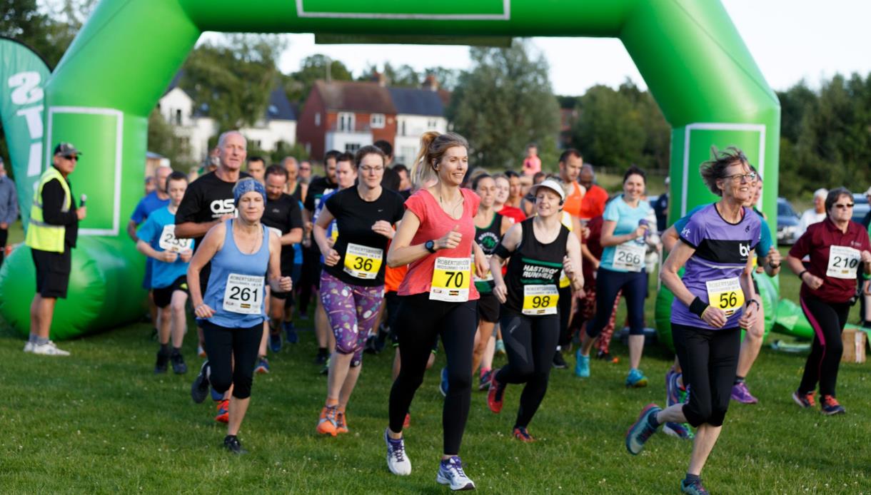 Participants set off at the start of the Robertsbridge Midsummer 10K and 5K race beneath a green inflatable arch.