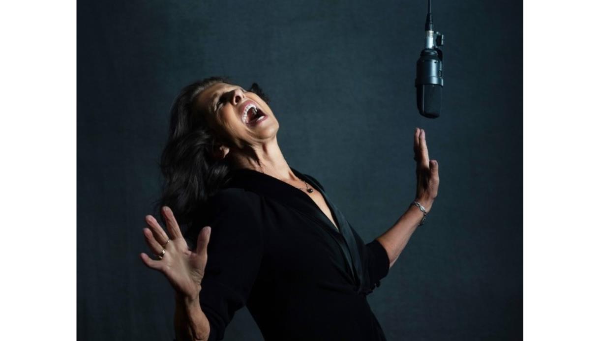 Elkie Brooks singing with raised hands beside a studio microphone, promoting a live show at the DLWP.