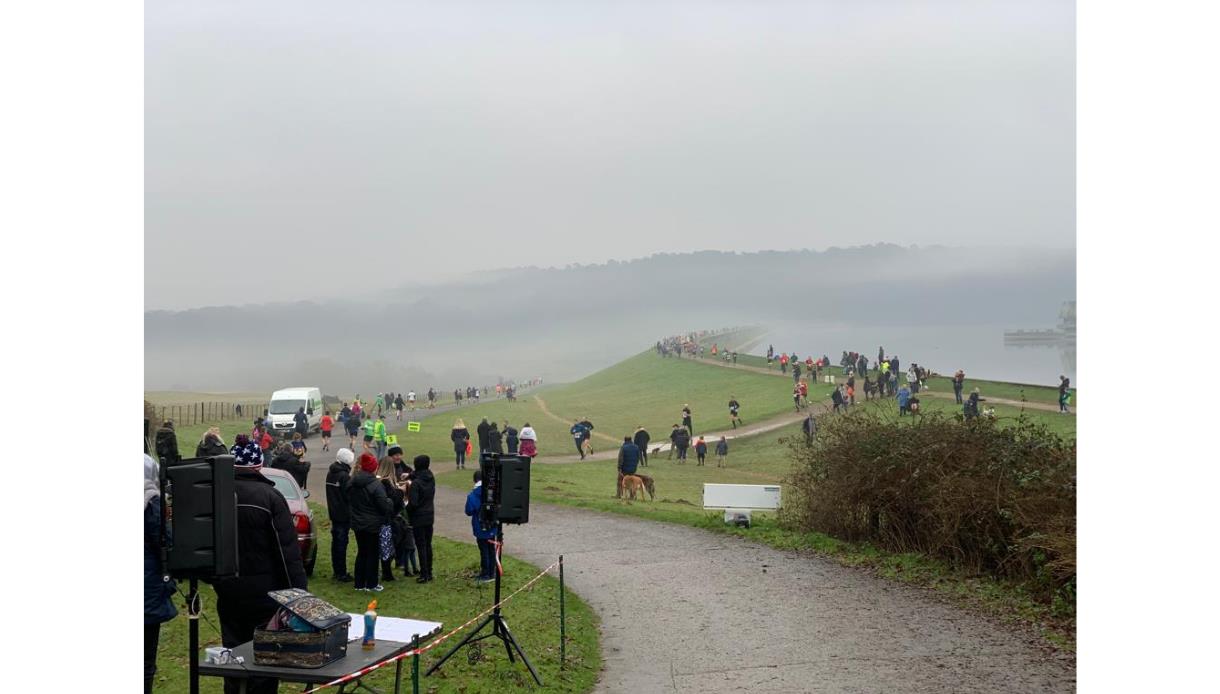 Participants and spectators line the route during the Bewl New Year 10K & 5K beside Bewl Water on a misty winter day