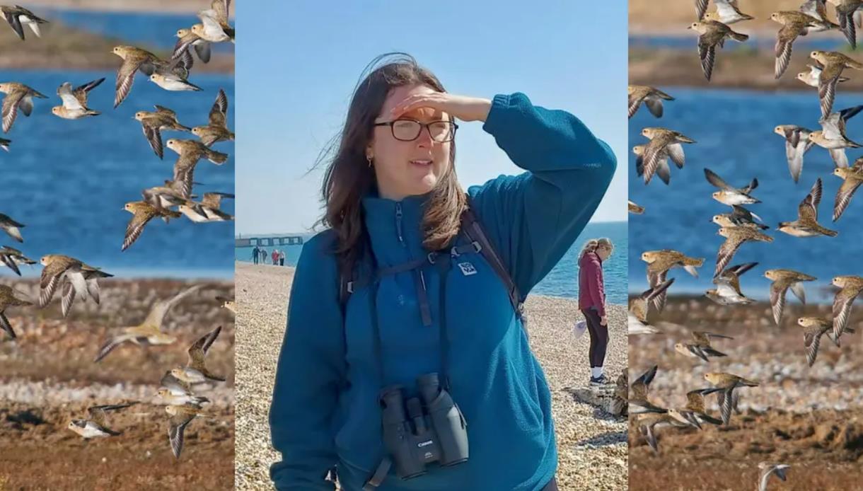 Person with binoculars at Rye Harbour Nature Reserve during a beginner birdwatching session, surrounded by flying birds.