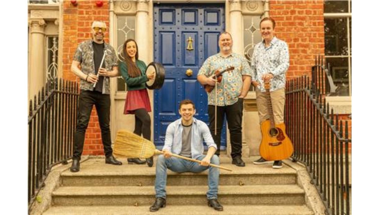 Group of five people posing on outdoor steps holding musical instruments.