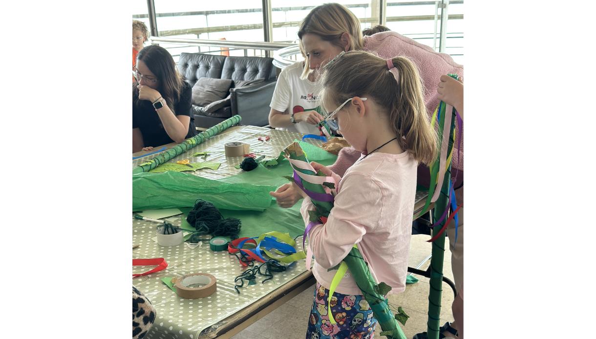 Image shows children and parents at a workshop at the De La Warr Pavilion doing arts and crafts.