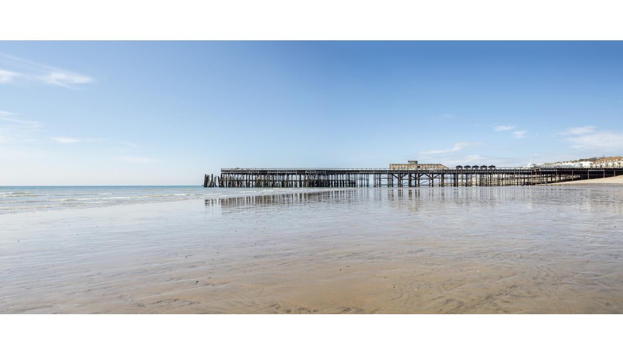 Hastings Pier at low tide viewed from the beach on the eastern side