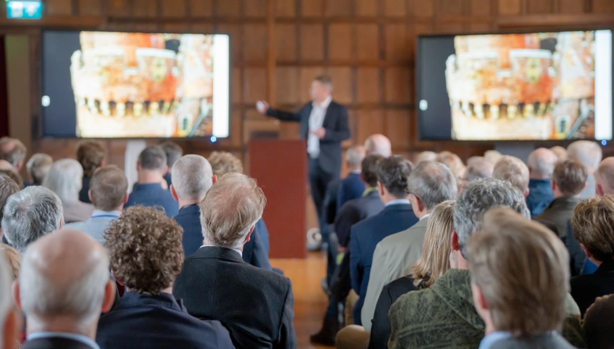 Audience watching a speaker present historic images during the Community Open Day at Herstmonceux Castle.