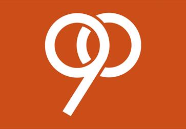 90th anniversary mark for the De La Warr Pavilion designed by Tom Geismar on an orange background.
