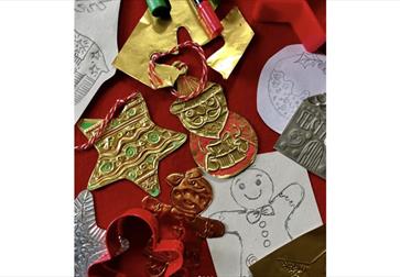 Festive ornament collection on red backdrop, seen from above. Red and gold color palette with round baubles, ribbed and smooth finishes, star shapes,