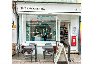 This image shows the outside of the Rye Chocolate shop in Hastings Old Town. You can see seating outside on the street plus the storefront.
