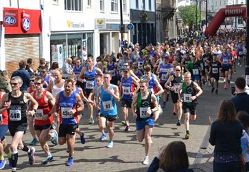 A photograph of a crowd of runners running down a Hastings street.