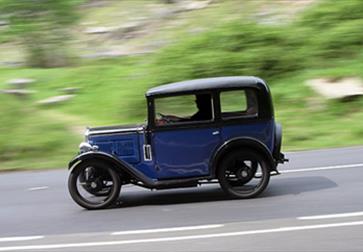 an Austin 7 vintage car on road with blurred background