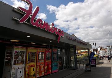 Outside of the Flamingo Amusements Hastings with large pink sign.