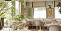 Bright, plant-filled dining room at The Gallivant with relaxed coastal style and natural light.