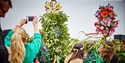 Jack in the Green figure covered in leaves and flowers surrounded by crowds during the Hastings Jack in the Green festival.