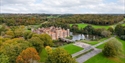 Aerial view of Herstmonceux Castle estate surrounded by lakes, woodland and countryside in East Sussex.