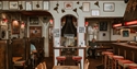 Traditional interior of the First In Last Out pub in Hastings with wooden booths and historic décor.