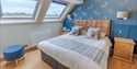 Bright double bedroom at The Regent, Rye, with skylights, blue stag wallpaper and countryside views.