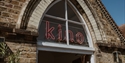 Historic cinema entrance at Kino Rye featuring its distinctive neon sign and brick façade.
