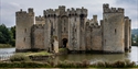 Bodiam Castle surrounded by its moat, showcasing towers, battlements and the historic gatehouse.